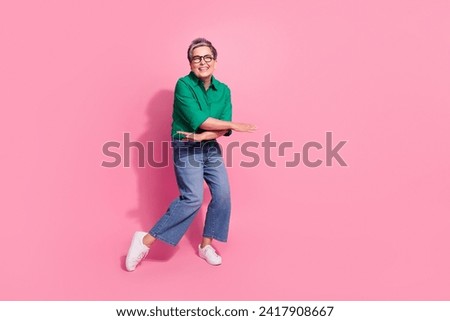 Full body photo of attractive pensioner woman dance have fun party dressed stylish green clothes isolated on pink color background