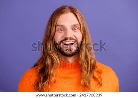 Photo of young blond long hair man with beard staring when realizes he can save 50 percent on shopping isolated over purple color background