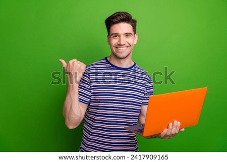 Portrait of cheerful attractive person hold wireless laptop indicate finger empty space isolated on green color background