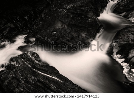 Abstract topographical landscape of waterfall in black and white colors,  Kent Falls State Park in Western Connecticut, USA, a long exposure photography
