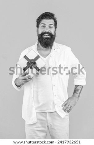 cheerful man offer sale gift in studio. man offer sale gift on background.