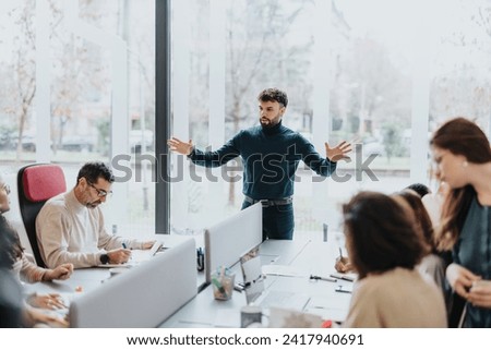 Successful business professionals in a vibrant office collaborating on projects. Happy team in a dynamic co-working space achieving successful results. Royalty-Free Stock Photo #2417940691
