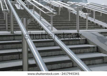 Beautiful stainless steel handrails are installed on the walls and steps at football stadium.