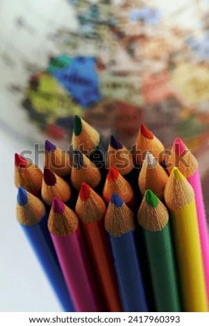 Colorful pencils with globe in the background