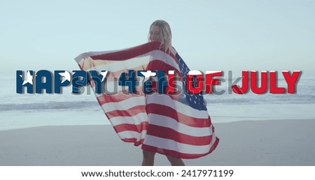 Image of happy 4th of july text with american flag pattern, woman wrapped in usa flag on beach. usa, patriotism and democracy concept digitally generated image.