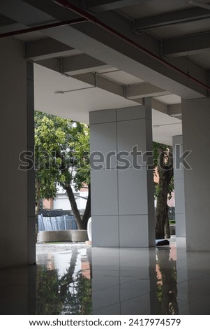 The pillars of the minimalist building are gray with clear lines and floors that are exposed to light in the morning