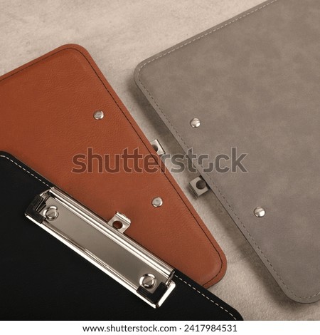 Colorful leather clipboard. Genuine leather clipboard, concept shot, top view, different color, clamshell and stitched clipboard
