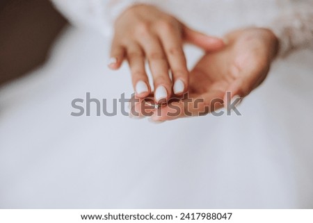 tender hands of a young woman with an expensive ring and a beautiful manicure. Close-up photo of female hands