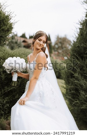 Beautiful bride with wedding flowers bouquet, attractive woman in wedding dress. Happy newlywed woman. Bride with wedding makeup and hairstyle. Smiling bride. Wedding day. Gorgeous bride. Marriage. Royalty-Free Stock Photo #2417991219