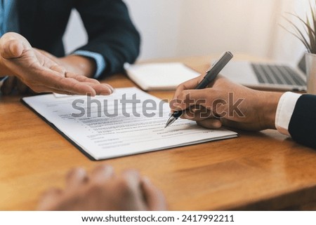 businessman sitting at desk holds pen signing contract paper, lease mortgage, employment hr or affirm partnership