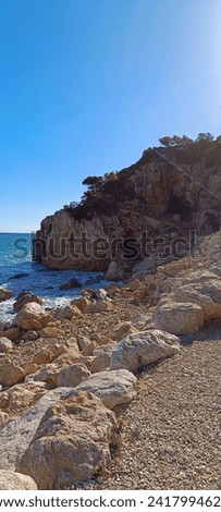 Rocky Sea with Blue Water, Sand and beautiful Rocks, Cloudy Sky