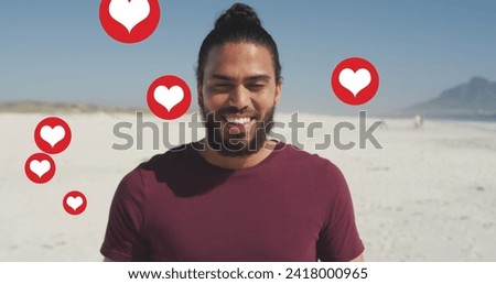 Image of social media red heart love icons over smiling man on beach. digital interface, social media and global network concept digitally generated image.