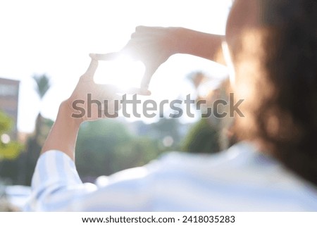 Young african american woman doing photo gesture with hands at street