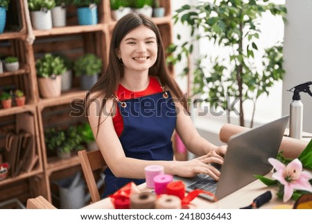 Young caucasian woman florist smiling confident using laptop at florist