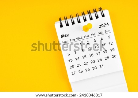 May 2024 Monthly desk calendar for 2024 year with thumbtack on yellow background.