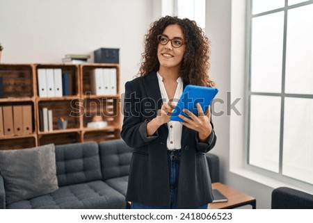 Young beautiful hispanic woman business worker smiling confident using touchpad at office