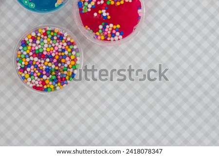 Colorful slime close-up mixed with decorations checkered background.