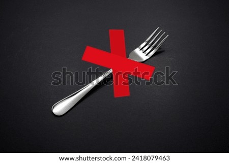 A single fork isolated on dark background with no sign in red color close up view, Food control or diatry concept photography 