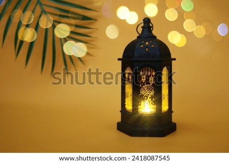 Ramadan lantern with Islamic carvings on a dark background. Happy Ramadan. Translated The Arabic writing on the lantern means "Ramadan Kareem".
