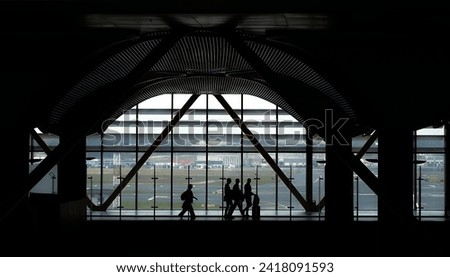 Silhouette of People Walking Against Lounge Window. Istanbul Modern International Airport. Flying, airplane transportation, business travel. Passangers at lobby. High quality photo Royalty-Free Stock Photo #2418091593