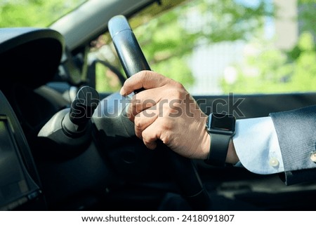 An office worker in his 50s gripping the steering wheel Royalty-Free Stock Photo #2418091807