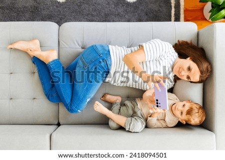 Mother and Child Taking Selfie on Couch