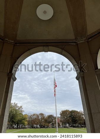 Looking through an open arch to a beautiful, waving, American Flag.