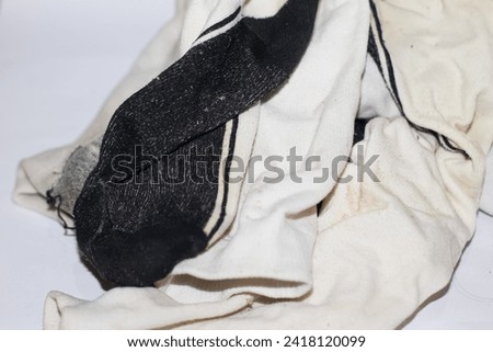  pile of dirty socks lying on isolated white background, showing various colors and patterns.