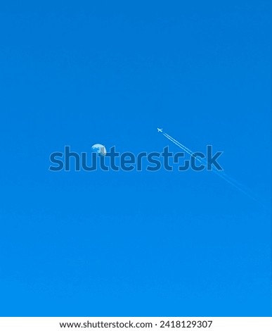 Aero plane crossing the moon in clear blue skyline. Amazing capture of moon crossing by plane in deep blue sky. Royalty-Free Stock Photo #2418129307
