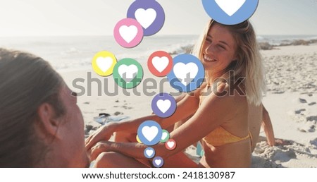 Image of heart digital icons over friends having fun on beach. digital interface, social media and global technology concept digitally generated image.