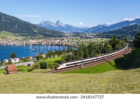 Passenger train type Stadler Giruno Smile of Schweizerische Bundesbahnen SBB at Grosser Mythen mountain at Lake Zug in the Swiss Alps in Arth, Switzerland Royalty-Free Stock Photo #2418147737