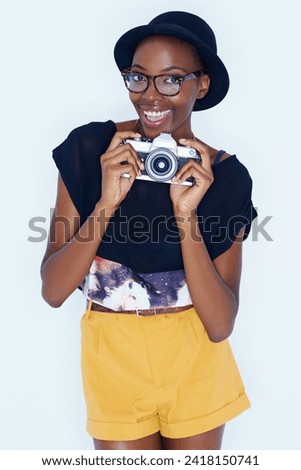 Black woman, photographer and portrait in studio with smile, creativity and camera for talent and creative artist career. Student, happiness and face for photography and glasses by white background