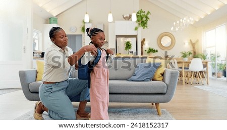 Talking, happy and a mother with a child getting ready for school in the morning. Kiss, laughing and an African mom helping a little girl with a bag in the living room of a house for kindergarten Royalty-Free Stock Photo #2418152317