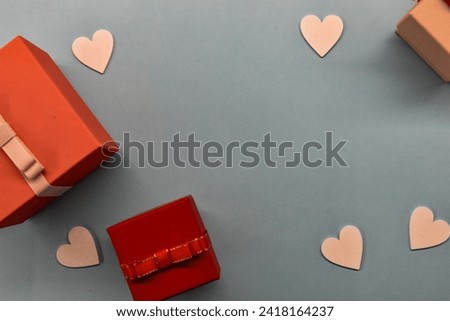 Enchanting Valentine's Harmony: Red, Dark Pink, and Light Pink Gift Boxes, White Hearts on a Soothing Blue Background