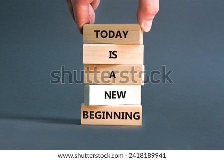 Today is a new beginning symbol. Concept words Today is a new beginning on wooden blocks. Beautiful grey table grey background. Businessman hand. Business today is a new beginning concept. Copy space.