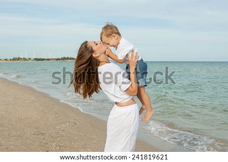 Happy family. Young beautiful  mother and her son having fun on the beach. Positive human emotions, feelings, joy.