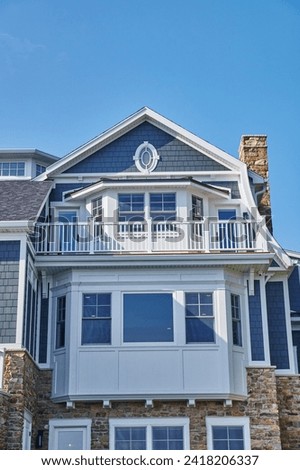 Luxurious Coastal House with Blue Shingles and Stone Foundation Royalty-Free Stock Photo #2418206337