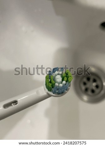 Electric tooth brush head, Close up picture with white sink basin in background