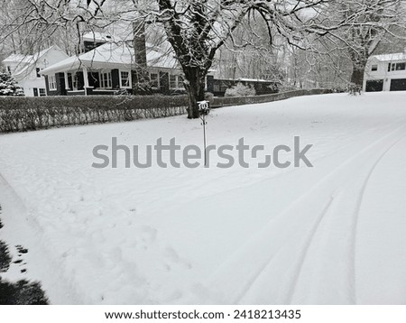 A civic sign standing straight in the middle of a snow covered lawn.