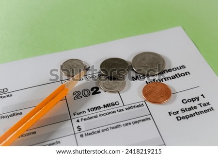 1099 Misc Tax Form for tax season with money and pencil against green background Royalty-Free Stock Photo #2418219215