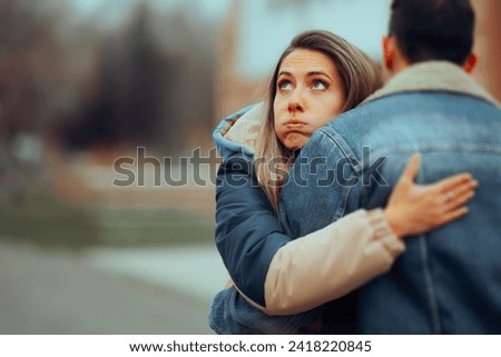 
Insincere Girlfriend Hugging her Boyfriend on a Date. Bored woman keeping a guy in the friend zone giving him false hope 
