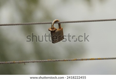 Padlock locked in a bridge wire as a live symbol 