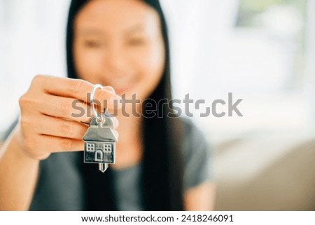 A female hand holds a house key showcasing confidence and success in real estate. Reflecting happiness achievement and the excitement of buying a new home.