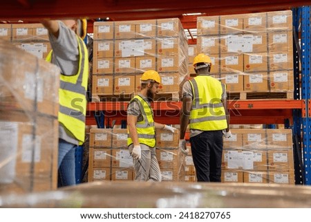 Handsome Male Worker Wearing a Hard Hat Walking Through a Retail Warehouse Full of Shelves with Goods. Working in the Logistics and Distribution Center.