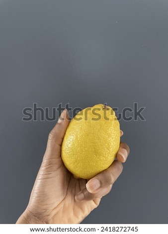 A concept image of a black person holding a lemon in their hand