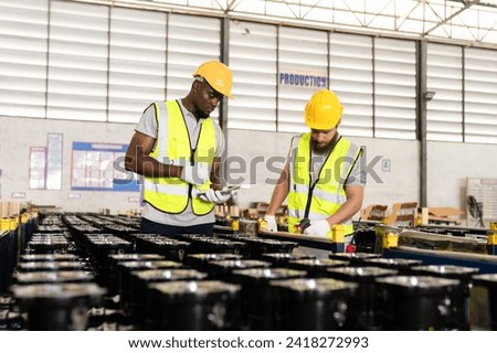 A professional male Worker Wearing a Hard Hat Checks Stock and Inventory with a Digital Tablet Computer and Walks in the Retail Warehouse full of Shelves with Goods. Working in Delivery, Distribution.