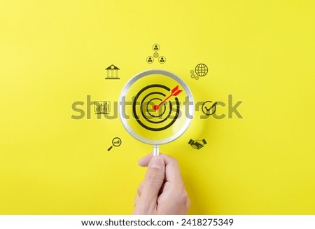 Business growth and marketing target concepts. Holding a magnifying glass with aim bullseye icon and other business icons. Goal objective strategy plan action, Target success, Achievement company,