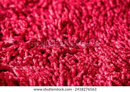 Red carpet texture background. Bright red fancy cotton carpet close-up photo.