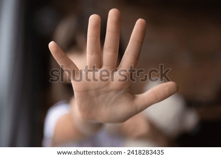 Stop. Blurred shot of little girl stretch hand show no sign mean prepare enough domestic violence bullying abuse violation of children rights. Close up focus on child palm making prohibition gesture Royalty-Free Stock Photo #2418283435