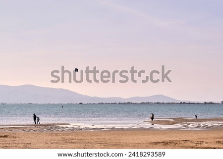 Many people go to Trabucador beach, in the Ebro delta, Catalonia, to walk and enjoy shallow waters, beautiful sunsets, birds and good food. Land of rice. Royalty-Free Stock Photo #2418293589